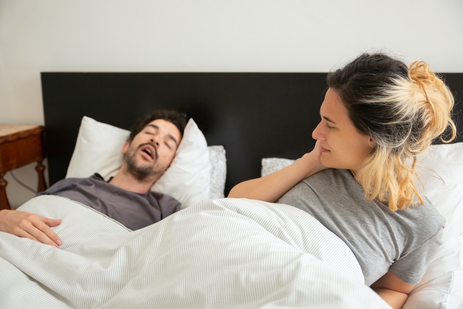 Woman Lying on Bed with a Man snoring